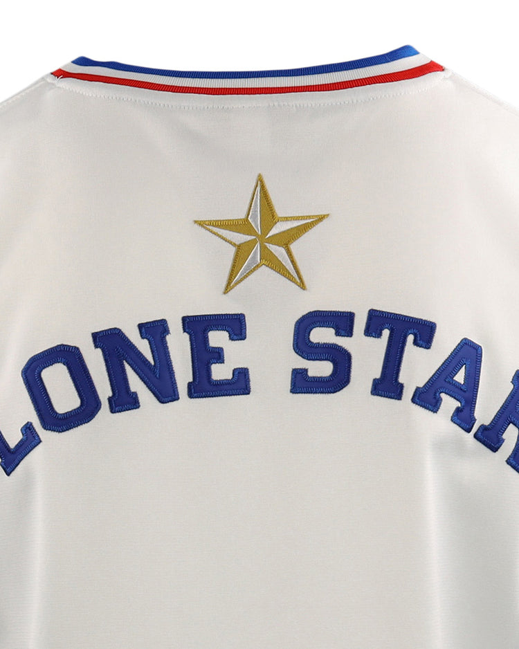 Close-up of the McAllen Dusters EFF Lone Star Baseball Jersey by EFF, featuring LONE STAR in blue letters with a gold star above and red and blue stripes on the collar, worn on a local school district baseball field.