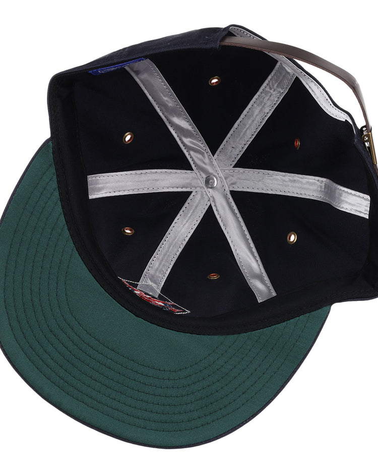 The image shows the inside of an EFF Columbus Red Birds cotton twill ballcap featuring a green brim, silver inner hatband strips, ventilation holes, and an adjustable brown leather strap with a metal buckle.