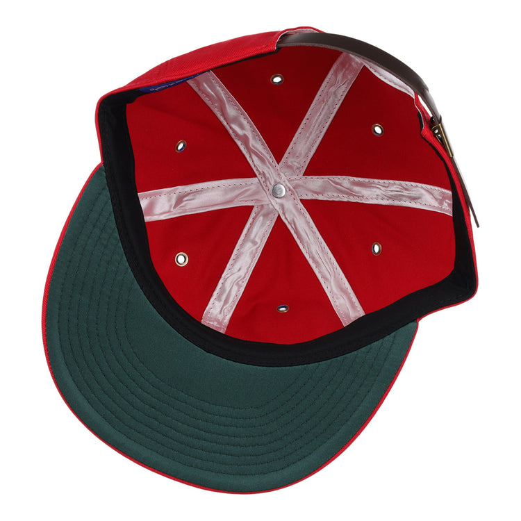 The image shows the Des Moines Demons Cotton Twill Ballcap by EFF, featuring a red cotton build, green underbrim, white stitching, brown adjustable strap, and demons patch—ideal for any summer series style.