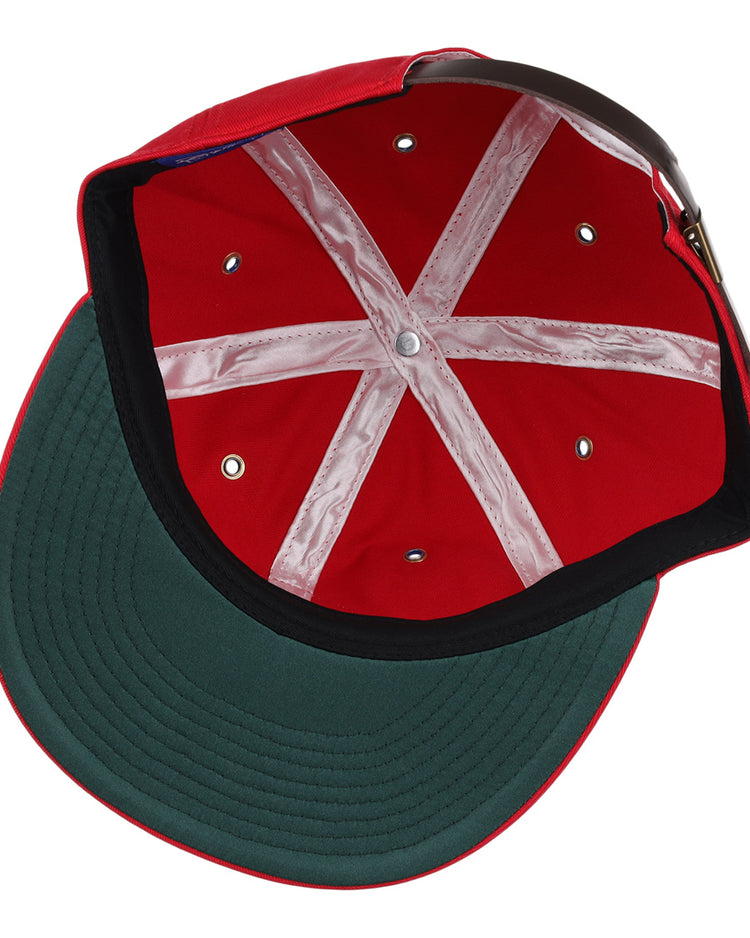 The image shows the Des Moines Demons Cotton Twill Ballcap by EFF, featuring a red cotton build, green underbrim, white stitching, brown adjustable strap, and demons patch—ideal for any summer series style.