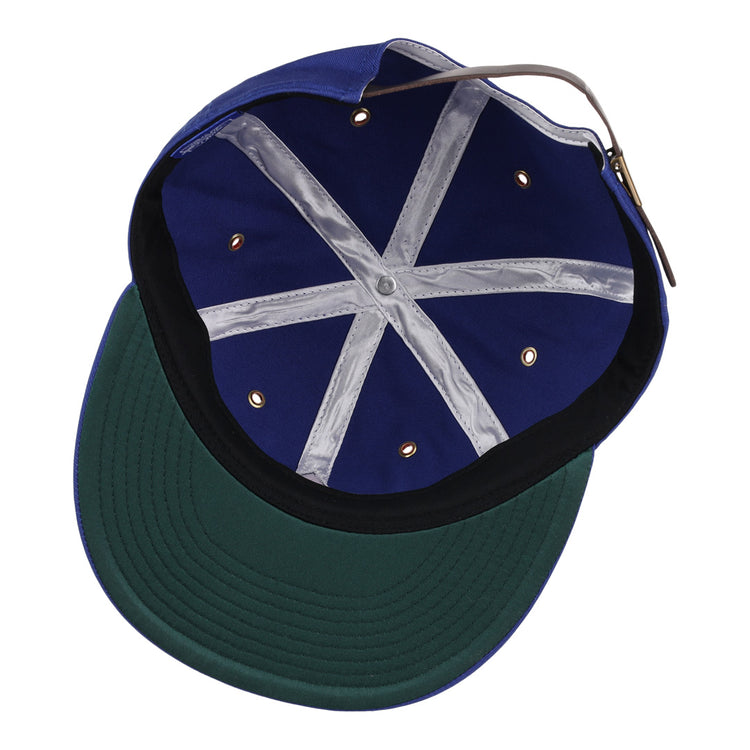 The image shows the inside of the EFF Hollywood Stars Cotton Twill Ballcap, featuring a blue design inspired by the Pacific Coast League, a green underbrim with black edging, gold vents, white crisscross tape, and an adjustable back strap.