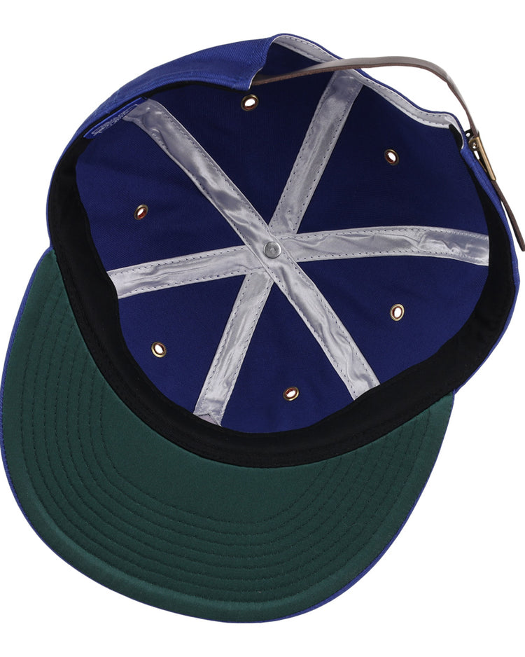 The image shows the inside of the EFF Hollywood Stars Cotton Twill Ballcap, featuring a blue design inspired by the Pacific Coast League, a green underbrim with black edging, gold vents, white crisscross tape, and an adjustable back strap.