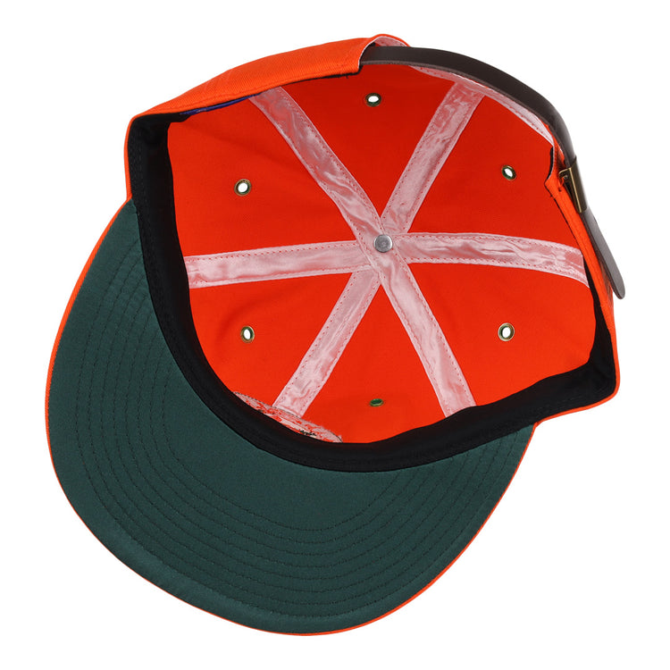 The image shows the inside of an EFF Miami Beach Flamingos Cotton Twill Ballcap, featuring orange cotton fabric, a green underbrim, white sweatbands in an X shape, and an adjustable leather strap at the back.