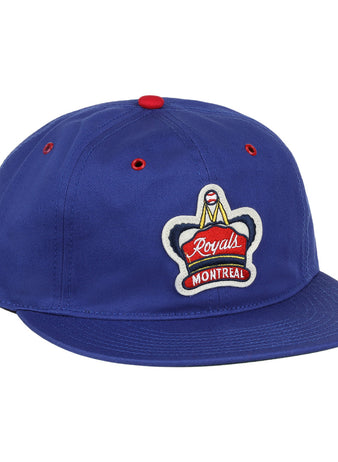 The EFF Montreal Royals Cotton Twill Ballcap is blue cotton with a red top button, red eyelets, and an embroidered Royals Montreal patch featuring a crown on the front.