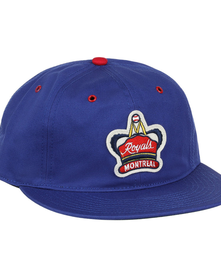 The EFF Montreal Royals Cotton Twill Ballcap is blue cotton with a red top button, red eyelets, and an embroidered Royals Montreal patch featuring a crown on the front.