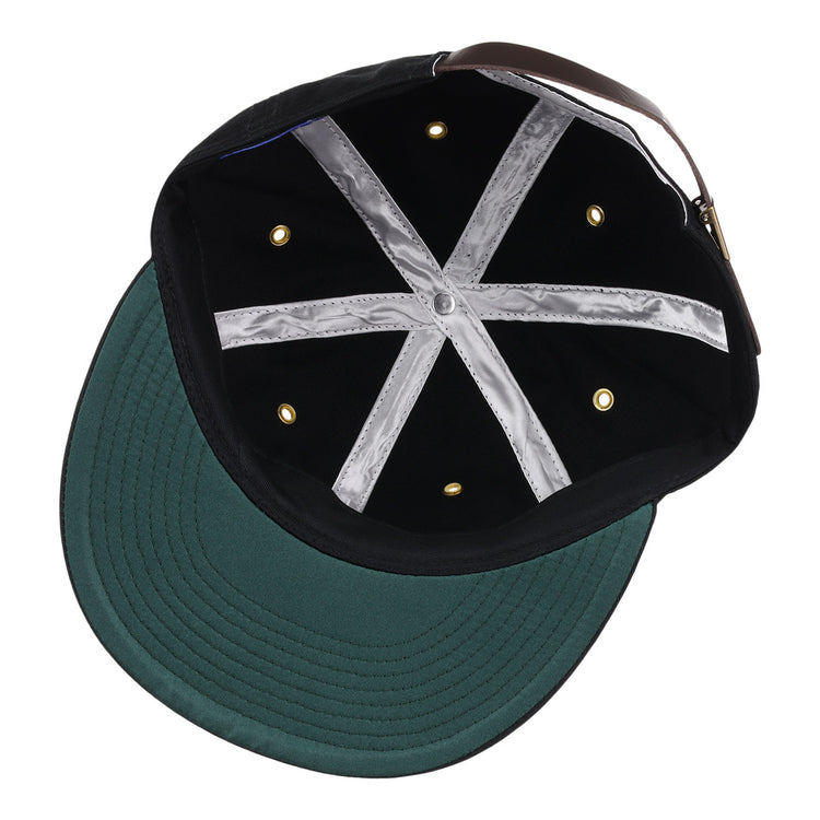 The EFF New Orleans Pelicans Cotton Twill Ballcap in black features a green brim, six gold ventilation holes, silver hatband lining, and an adjustable brown strap with gold buckle—plus a tribute to the Southern Association for vintage flair.