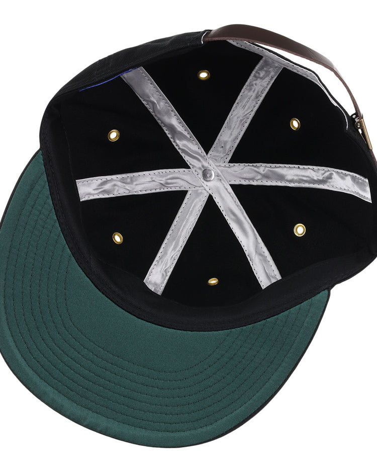 The EFF New Orleans Pelicans Cotton Twill Ballcap in black features a green brim, six gold ventilation holes, silver hatband lining, and an adjustable brown strap with gold buckle—plus a tribute to the Southern Association for vintage flair.