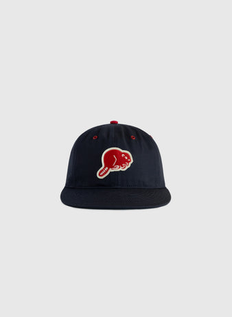 The EFF Portland Beavers Cotton Twill Ballcap in navy features a red and white embroidered fish logo on the front, evoking a vintage style, and is displayed against a plain light gray background.