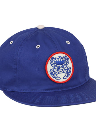 The EFF Santurce Cangrejeros Cotton Twill Ballcap is royal blue with a white and red patch showing a crowned blue cartoon crab, plus white eyelets and a top button—ideal for fans of the Cangrejeros.