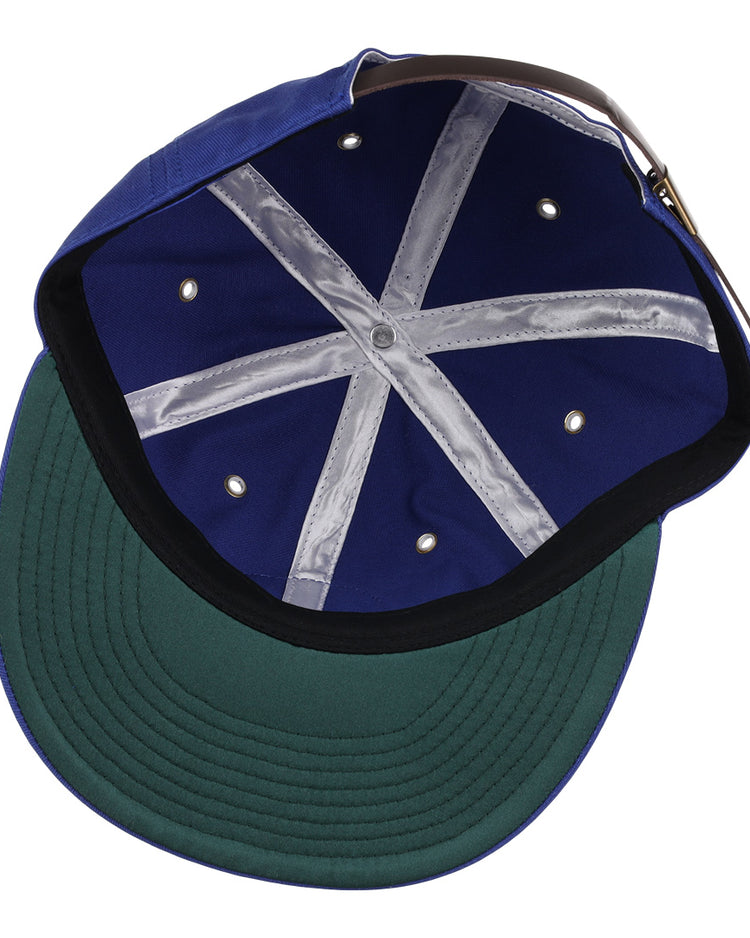 Inside the EFF Santurce Cangrejeros Cotton Twill Ballcap: a green underbrim, navy blue interior, X-pattern grey taped seams, metal ventilation holes, and an adjustable brown strap at the back.