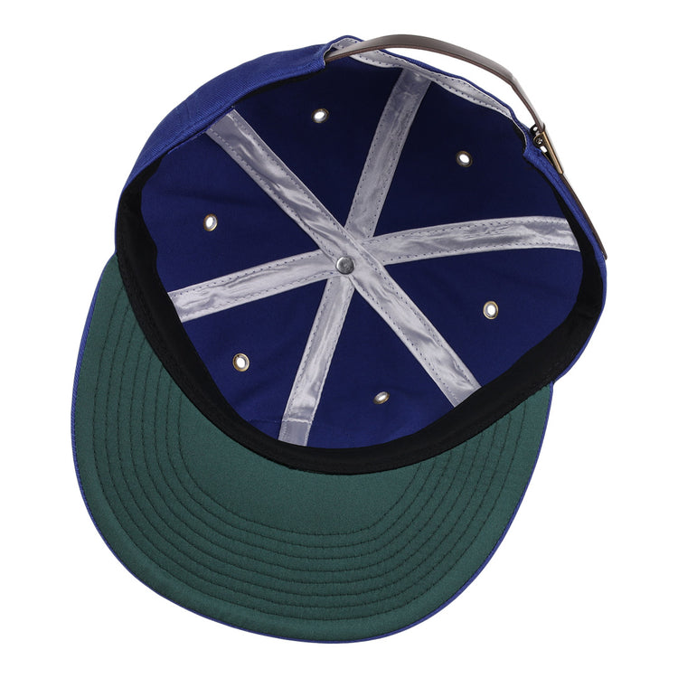 An overhead view of the EFF Trois Rivières Royals Cotton Twill Ballcap shows its royal blue cotton interior, green underbrim, grey adjustable strap, white stitched crown bands, and metal ventilation holes.