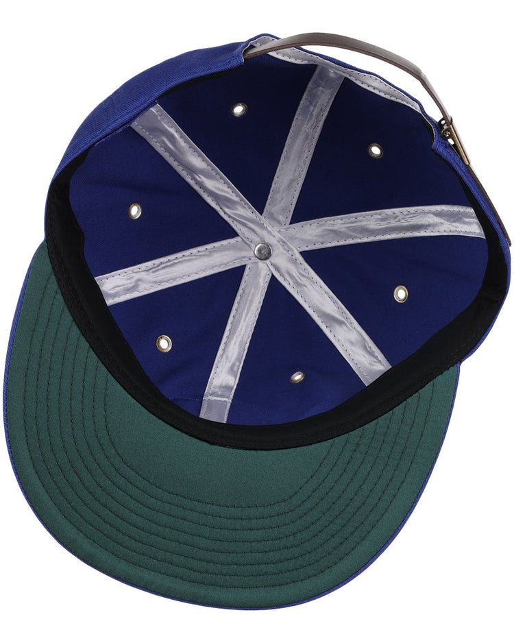 An overhead view of the EFF Trois Rivières Royals Cotton Twill Ballcap shows its royal blue cotton interior, green underbrim, grey adjustable strap, white stitched crown bands, and metal ventilation holes.