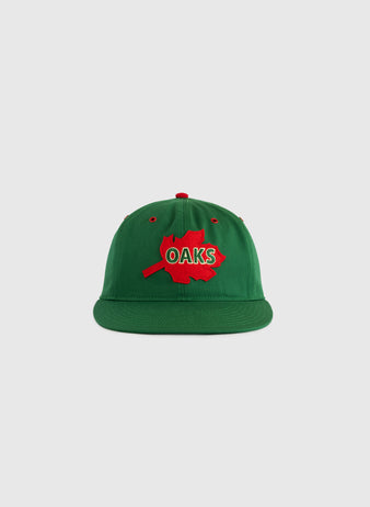 The EFF Oakland Oaks Cotton Twill Ballcap is a green hat featuring a red maple leaf patch and bold red and white OAKS lettering, shown against a plain light gray background.