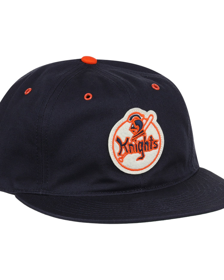 The EFF New York Knights Cotton Twill Ballcap features a black cotton build, orange button and eyelets, and a front patch with a knight holding a sword and Knights in orange, inspired by The Naturals New York Knights.