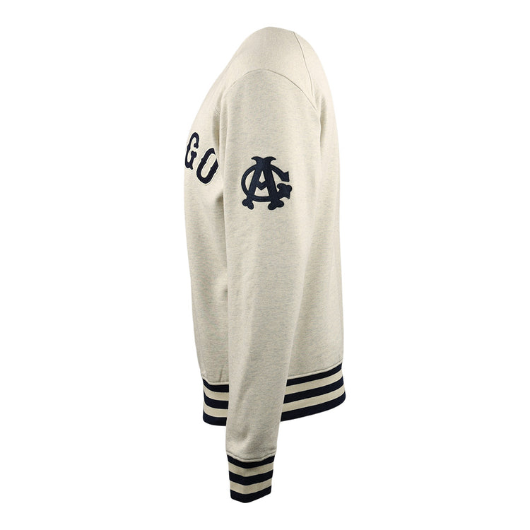 Side view of a beige Chicago American Giants EFF NLB Corduroy Crewneck by EFF, featuring navy blue chest letters, a stylized C logo on the sleeve, and navy striped cuffs and waistband.
