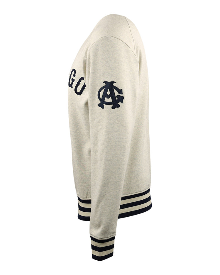 Side view of a beige Chicago American Giants EFF NLB Corduroy Crewneck by EFF, featuring navy blue chest letters, a stylized C logo on the sleeve, and navy striped cuffs and waistband.