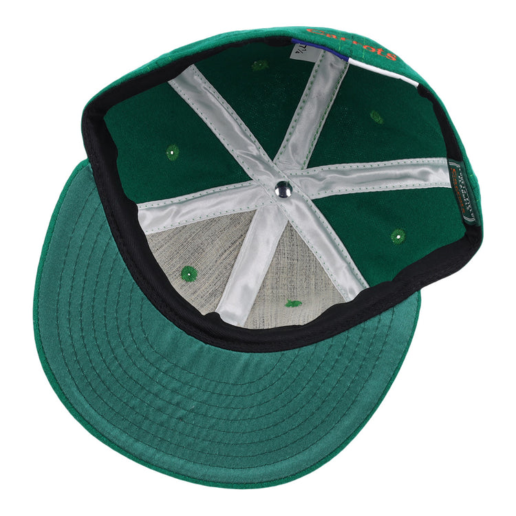 The image shows the underside of a green Carrots Arlington Heights Collection “C Ballcap by Ebbets Field Flannels, featuring white interior panels, green ventilation holes, and a black sweatband along the inner edge of the brim.