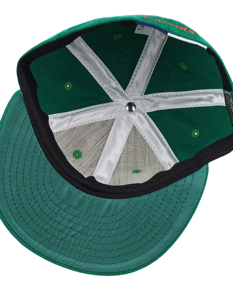 The image shows the underside of a green Carrots Arlington Heights Collection “C Ballcap by Ebbets Field Flannels, featuring white interior panels, green ventilation holes, and a black sweatband along the inner edge of the brim.