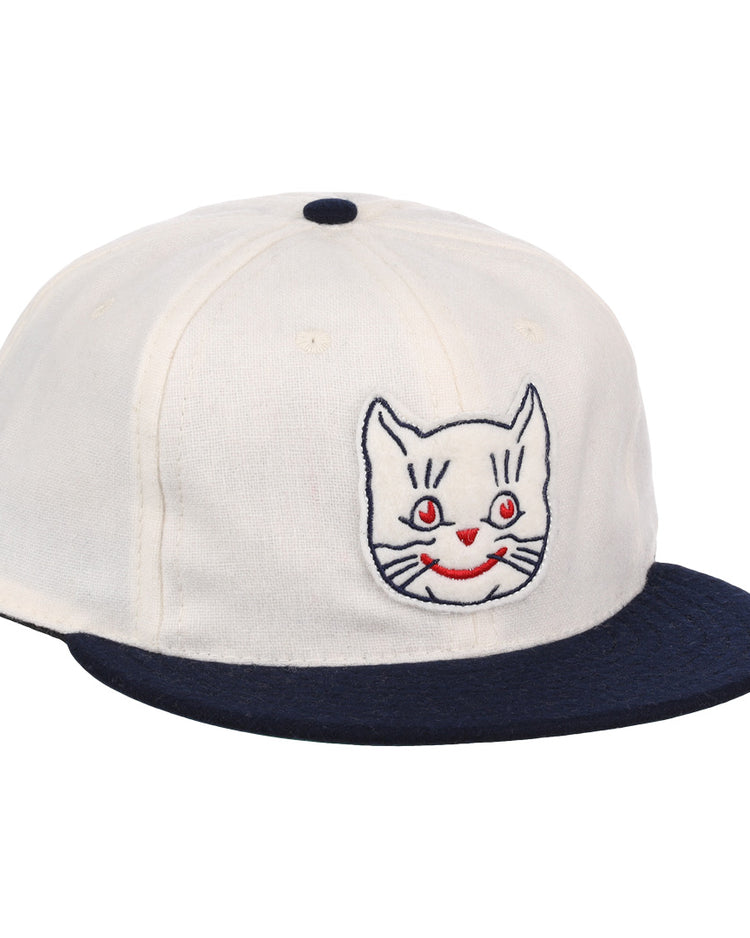 The EFF Kansas City Katz Off White Vintage Inspired Ballcap features a navy brim and button, plus an embroidered white cat face with red eyes and mouth—ideal for Katz ballcap collectors.