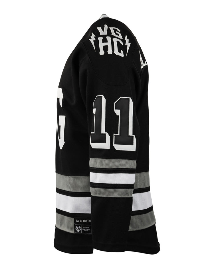 A black EFF Violent Gentlemen x EFF Collection Hockey Jersey with white and gray sleeve and waist stripes, white number 11 on the back, and VG HC near the collar, shown in side view on a mannequin.