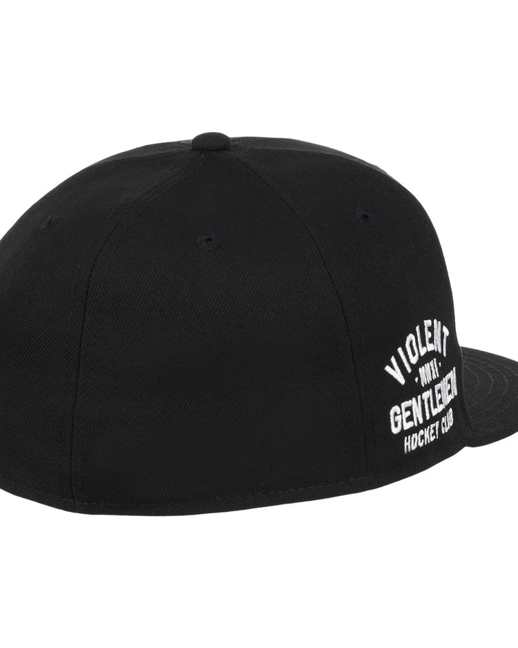 The Violent Gentlemen x EFF Collection Fitted Ballcap by EFF is a black, flat-brim fitted hat featuring white VIOLENT GENTLEMEN HOCKEY CLUB embroidery on the front, viewed from the back and side. Part of the hockey apparel collection.