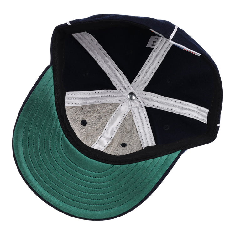 The image features the EFF Indianapolis Indians 1935 Vintage Ballcap, a navy blue cap with white stitched panels, a green underbrim, and a metal top button.