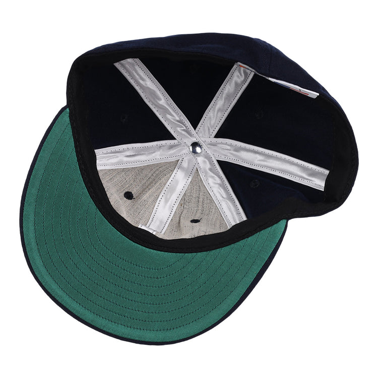 The image displays the inside of the EFF Twin Falls Cowboys 1947 Vintage Ballcap, featuring a green underbrim, gray wool crown panels, white inner seams, and a silver top button—all crafted from genuine baseball cloth.