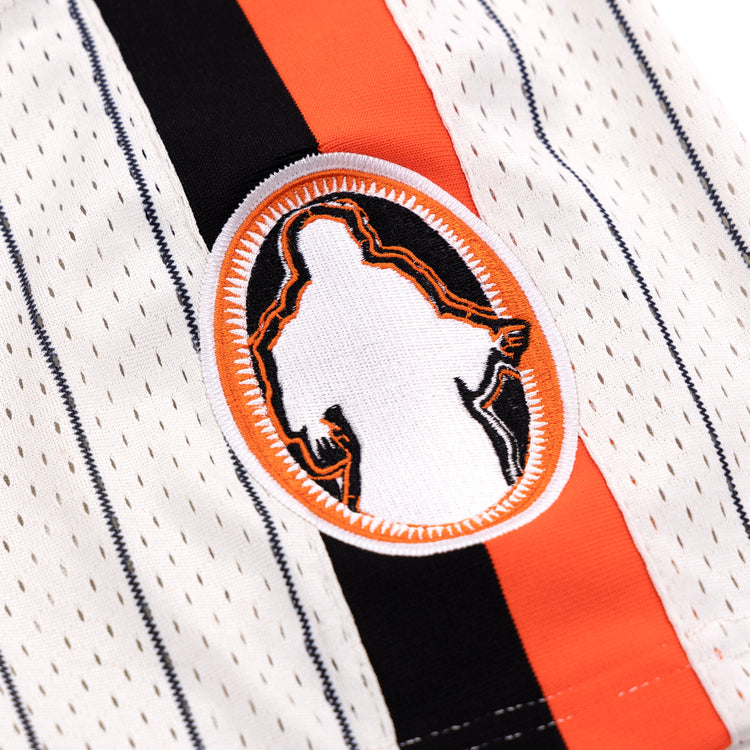A close-up of the Sioux City Ghosts EFF Pinstripe Button Down Jersey by EFF, featuring white fabric with black and orange pinstripes and an oval patch at the center showing a silhouette outlined in orange and black.