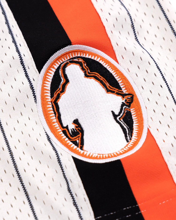 A close-up of the Sioux City Ghosts EFF Pinstripe Button Down Jersey by EFF, featuring white fabric with black and orange pinstripes and an oval patch at the center showing a silhouette outlined in orange and black.