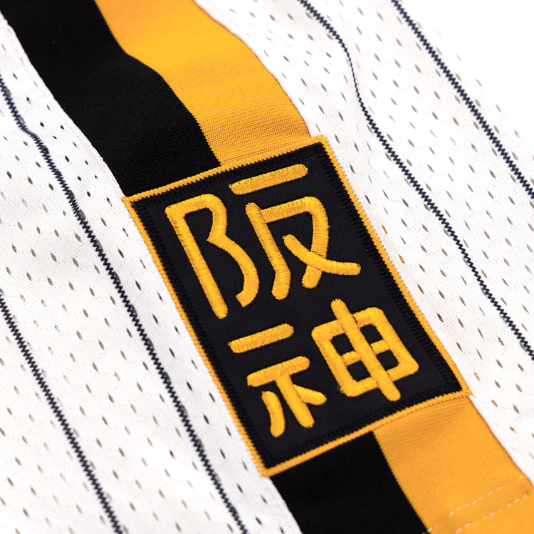 Close-up of the EFF Osaka Tigers EFF Pinstripe Button Down Jersey, showcasing yellow and black vertical stripes and a rectangular patch with bold yellow Japanese kanji, inspired by classic Osaka Tigers Black baseball jerseys.