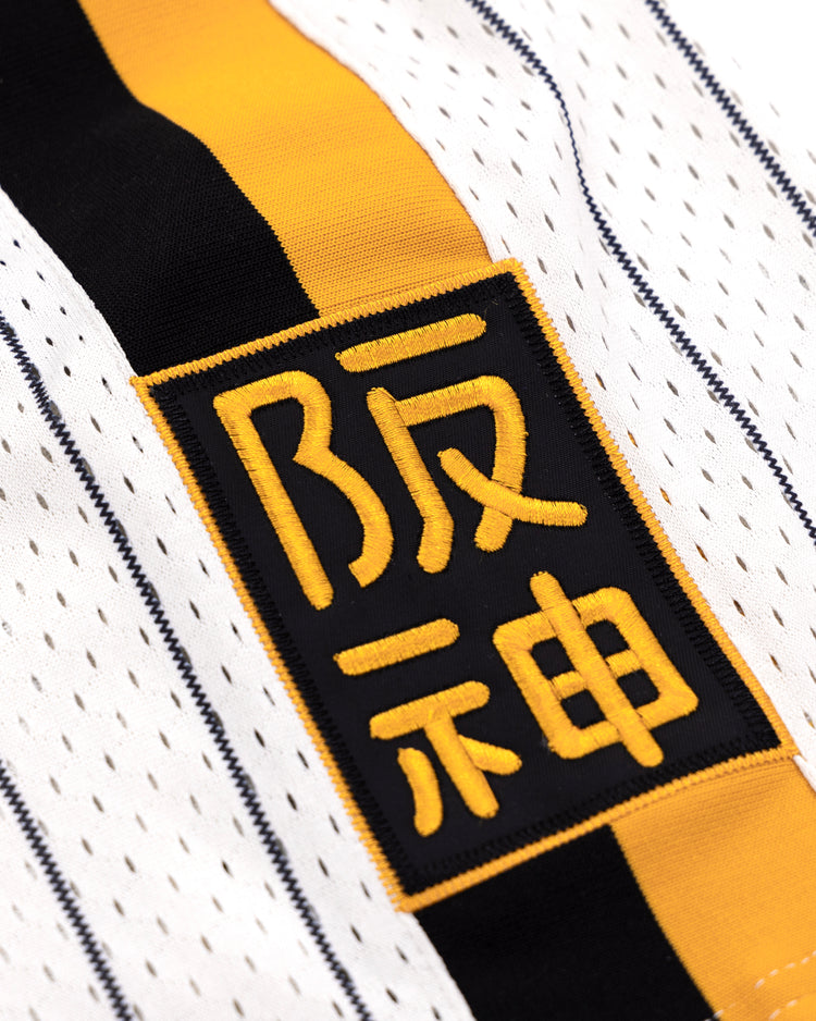 Close-up of the EFF Osaka Tigers EFF Pinstripe Button Down Jersey, showcasing yellow and black vertical stripes and a rectangular patch with bold yellow Japanese kanji, inspired by classic Osaka Tigers Black baseball jerseys.