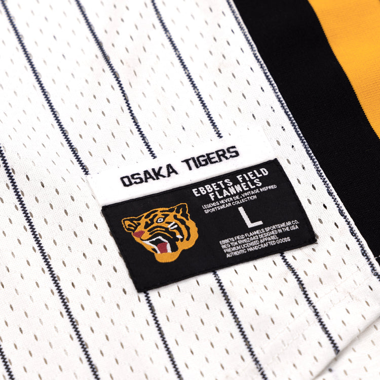 Close-up of the Osaka Tigers EFF Pinstripe Button Down Jersey by EFF, featuring OSAKA TIGERS lettering, a tiger logo patch, and distinctive labels. This classic pinstripe stands out among black baseball jerseys.