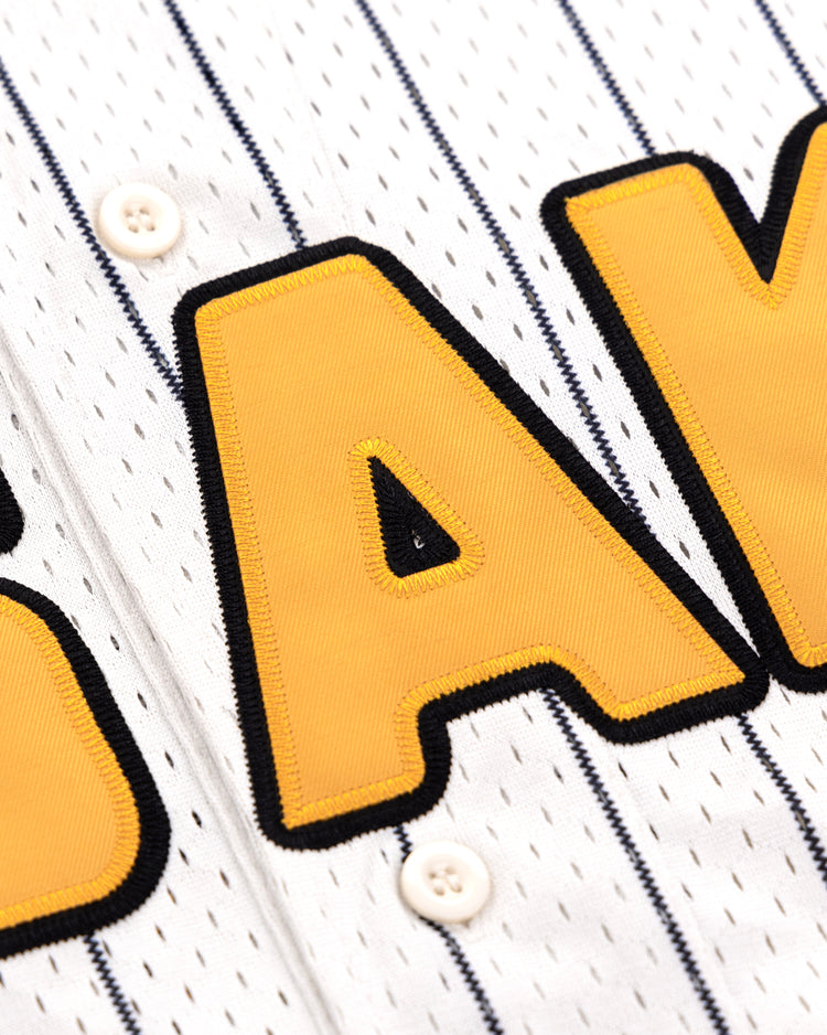 The EFF Osaka Tigers EFF Pinstripe Button Down Jersey features white pinstripes, bold yellow and black A K lettering, and two white buttons on the front placket, inspired by the Osaka Tigers.