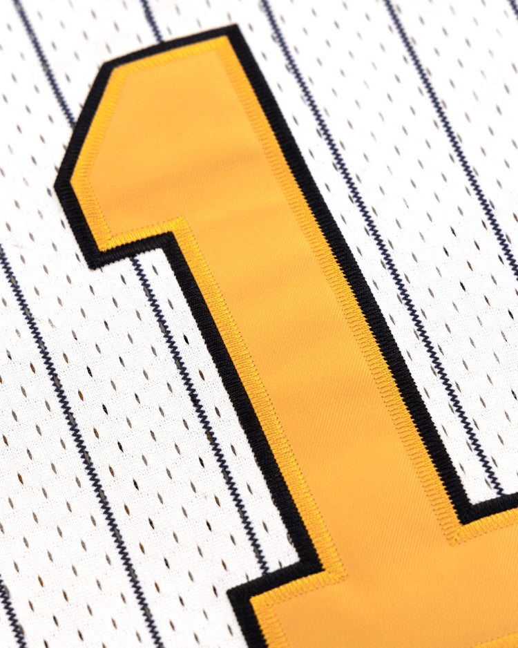 Close-up of a yellow number one outlined in black on the EFF Osaka Tigers EFF Pinstripe Button Down Jersey, featuring thin black stripes on white fabric.