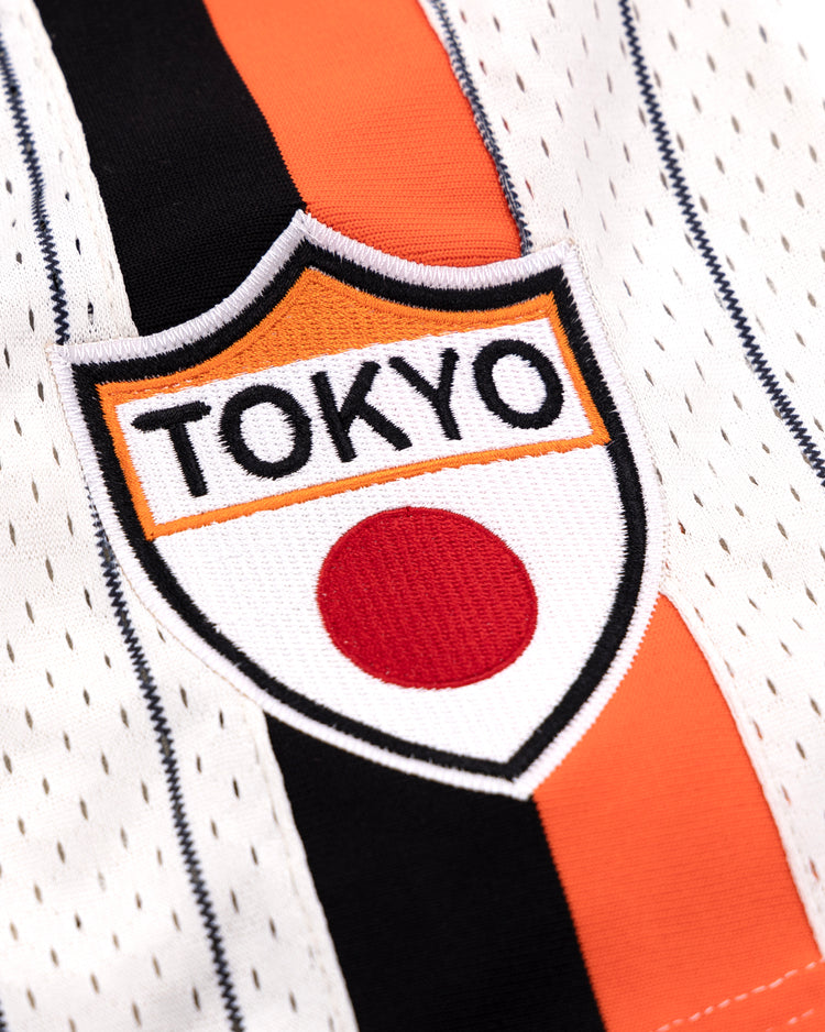 Close-up of the EFF Tokyo Giants Pinstripe Button Down Jersey, showcasing black, orange, and white stripes with a TOKYO patch above a red circle—paying tribute to the Tokyo Giants and Japans Black baseball heritage.