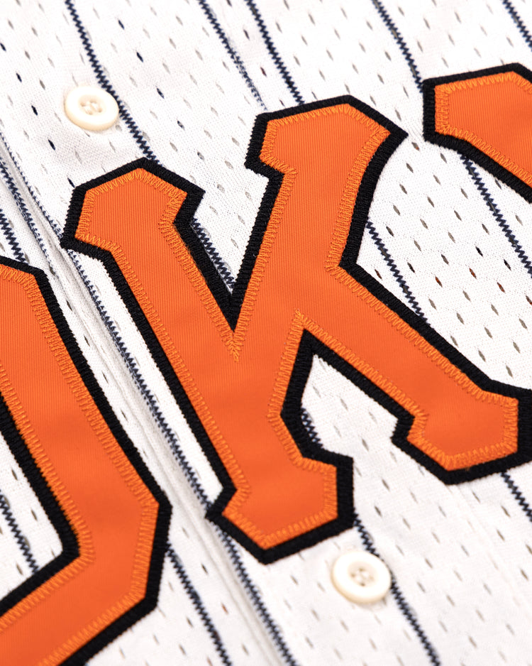 Close-up of the EFF Tokyo Giants Pinstripe Button Down Jersey, showing large orange O and K letters outlined in black and front white buttons.