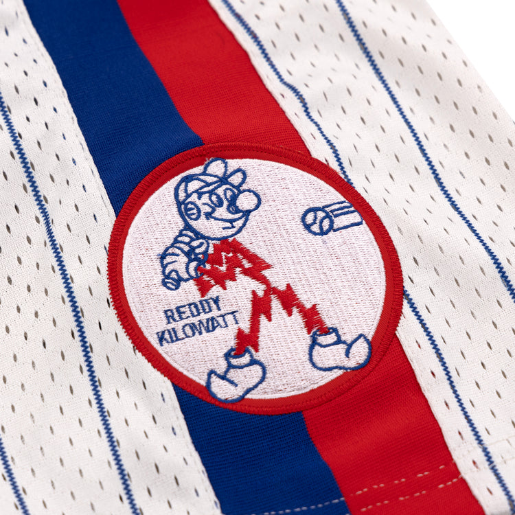 Close-up of the Reddy Kilowatt EFF Pinstripe Button Down Jersey by EFF—white with blue and red stripes, perforated holes, and a patch featuring cartoon baseball player Reddy Kilowatt above READY KILOWATT, bat, and ball.