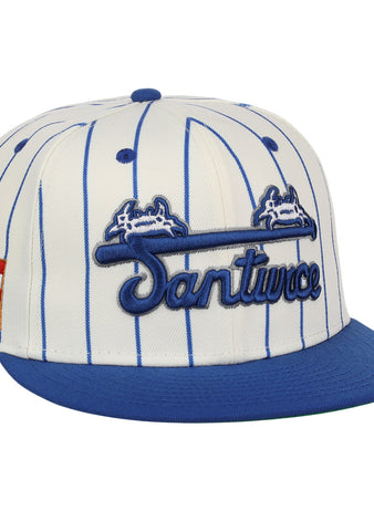 The EFF Santurce Cangrejeros Pinstripe Fitted Ballcap features blue pinstripes on white, a blue brim, Santurce embroidered on the front, and the Puerto Rican flag on the side to honor Puerto Rican League heritage.
