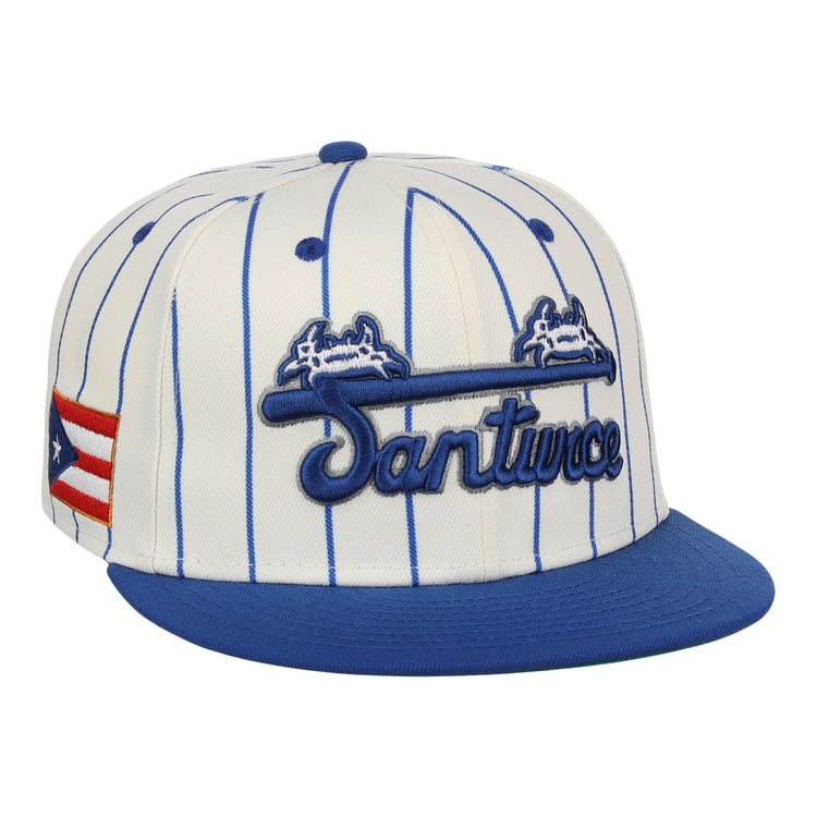 The EFF Santurce Cangrejeros Pinstripe Fitted Ballcap features blue pinstripes on white, a blue brim, Santurce embroidered on the front, and the Puerto Rican flag on the side to honor Puerto Rican League heritage.