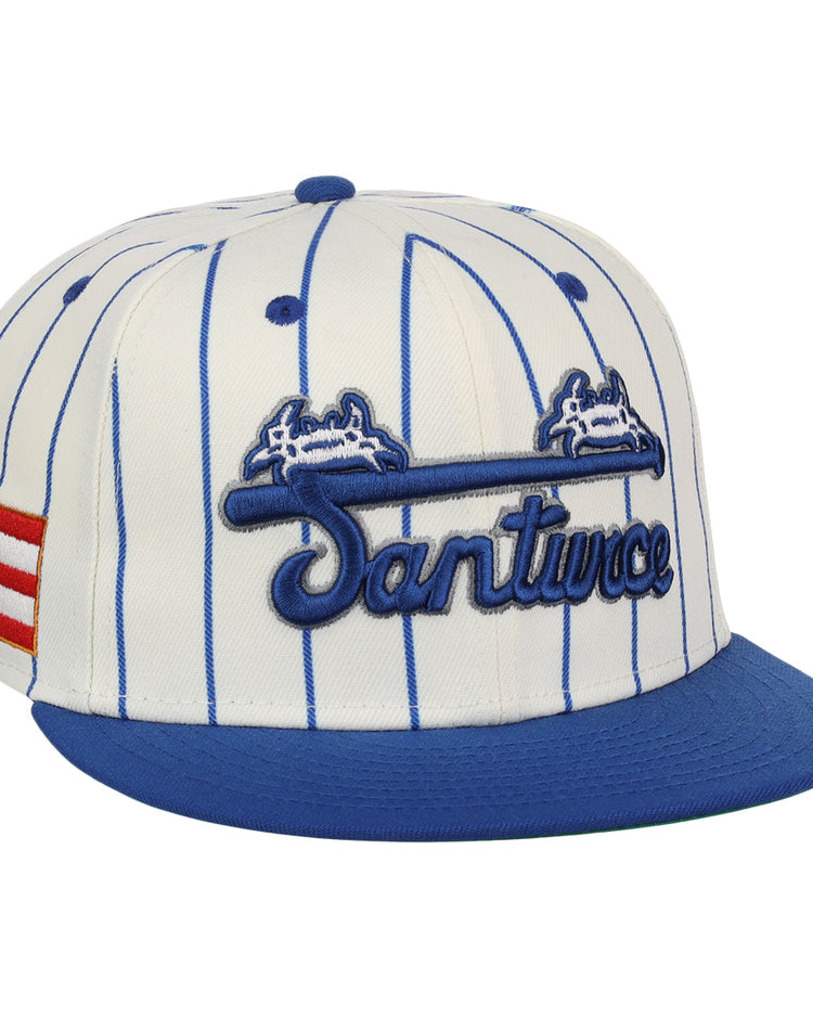 The EFF Santurce Cangrejeros Pinstripe Fitted Ballcap features blue pinstripes on white, a blue brim, Santurce embroidered on the front, and the Puerto Rican flag on the side to honor Puerto Rican League heritage.