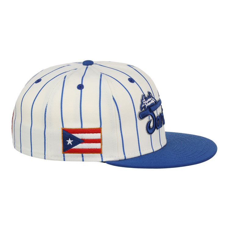The EFF Santurce Cangrejeros Pinstripe Fitted Ballcap features a white base with blue pinstripes, a blue brim, and Puerto Rican League tribute patches including the Puerto Rican flag on the side.