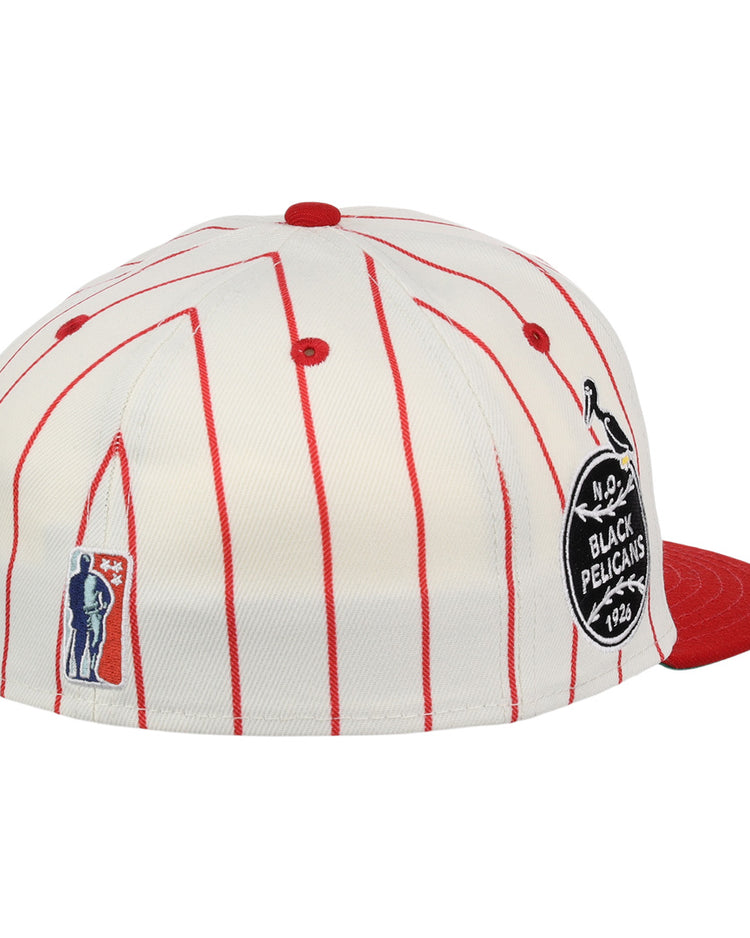 The EFF New Orleans Black Pelicans NLB Pinstripe Fitted Ballcap features red pinstripes, a red brim, a round BLACK PELICANS 1924 patch honoring the Negro Southern League team, plus embroidered figure and pelican accents on the side.
