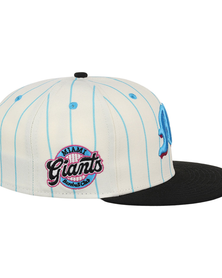 The EFF Miami Giants NLB Pinstripe Fitted Ballcap is a white cap with light blue pinstripes, a flat black brim, and an embroidered Miami Giants Baseball Club logo patch in pink and black on the side.