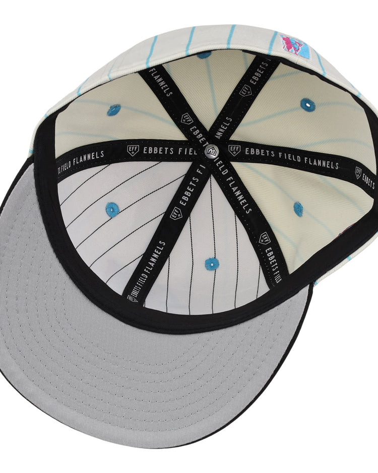 The EFF Miami Giants NLB Pinstripe Fitted Ballcap is shown from below, highlighting the gray underside of the brim, white crown with light blue pinstripes, blue eyelets, and black interior taping labeled EBBETS FIELD FLANNELS.