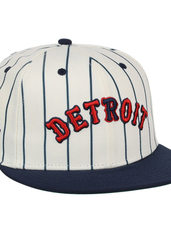 The EFF Detroit Stars NLB Pinstripe Fitted Ballcap features white fabric with navy blue pinstripes, a navy brim, and red DETROIT embroidery—honoring the Detroit Stars’ legacy.