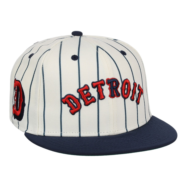 The EFF Detroit Stars NLB Pinstripe Fitted Ballcap features white fabric with navy blue pinstripes, a navy brim, and red DETROIT embroidery—honoring the Detroit Stars’ legacy.