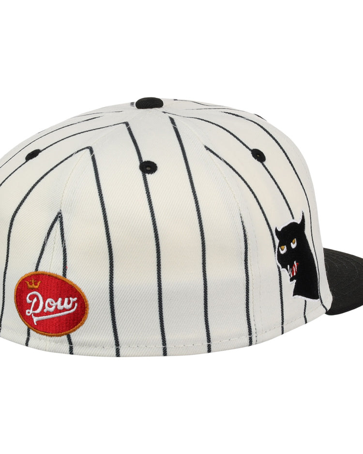 The EFF Montreal Black Panthers NLB Pinstripe Fitted Ballcap features black vertical pinstripes, a black brim, a red oval Pow patch on the side, and a small cartoon cat face with fangs near the front—ideal for Panthers fans.
