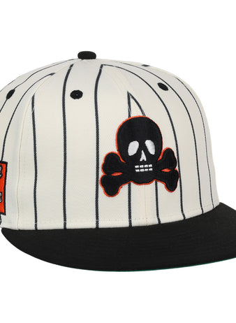 The EFF Sioux City Ghosts Pinstripe Fitted Ballcap features a white base with black vertical pinstripes, a black brim, a skull and crossbones patch on the front, and an orange rectangular graphic patch on the left side.