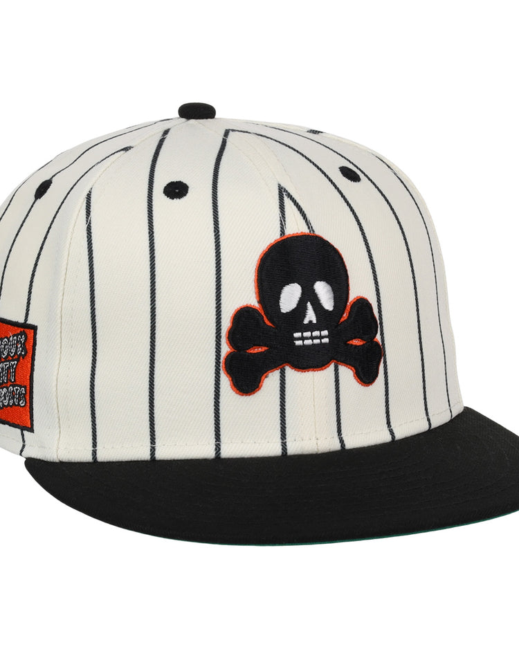 The EFF Sioux City Ghosts Pinstripe Fitted Ballcap features a white base with black vertical pinstripes, a black brim, a skull and crossbones patch on the front, and an orange rectangular graphic patch on the left side.
