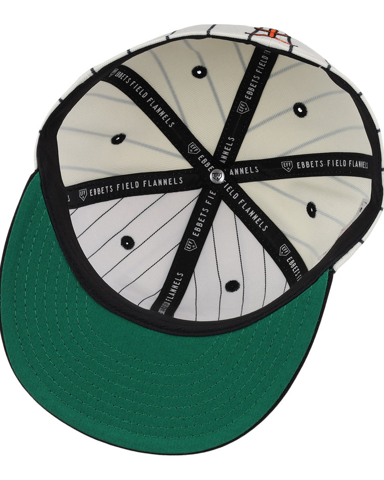 The Tokyo Giants EFF Pinstripe Fitted Ballcap by EFF features a green underside brim, black sweatband, and black-and-white pinstriped interior panels labeled “EBBETS FIELD FLANNELS,” plus black stitched eyelets on the panels.